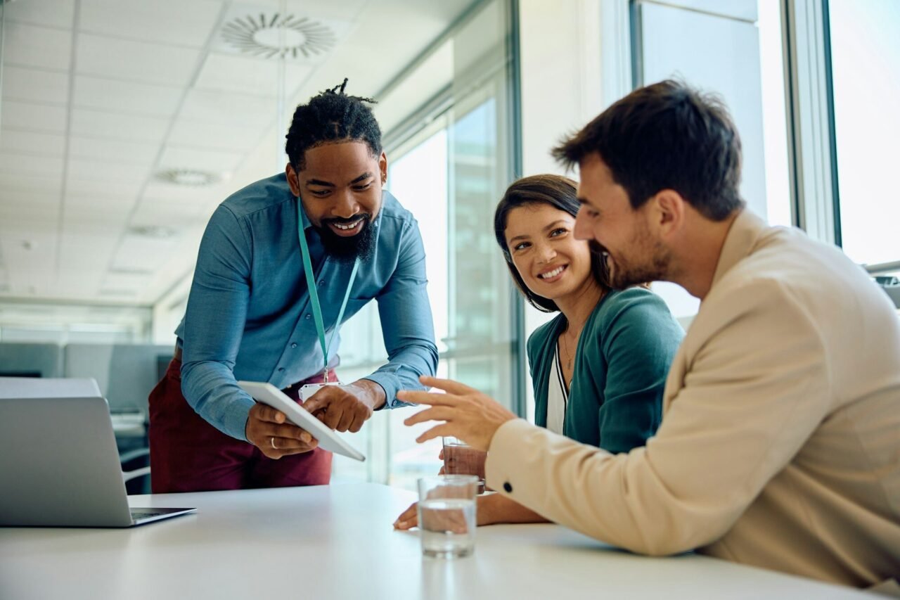 happy-black-financial-advisor-using-touchpad-with-his-clients-during-a-meeting-in-the-office-.jpg